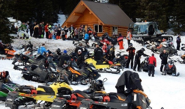 A huge group of riders all parked ouside a cabin in the Kakway Wildland Park. 