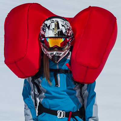 A woman snowmobiler with an airbag inflated. 