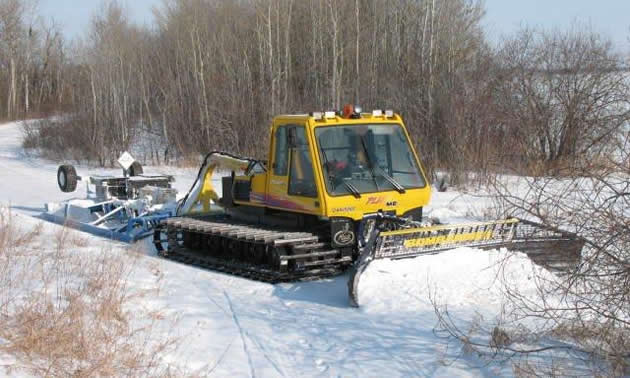 A snowmobile trail grooming machine out on the trail