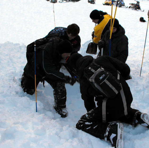 Three avalanche rescuers shovelling in an improper cone shape. 