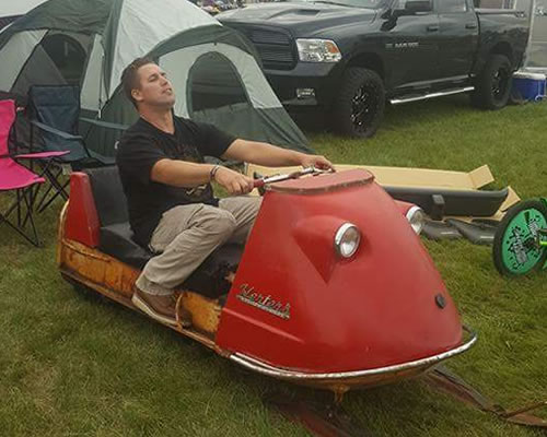 John Samolis sitting on his Herters snowmobile before it was restored. 