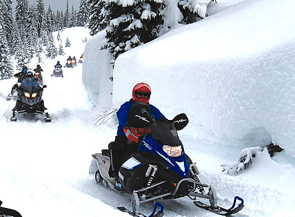 People on snowmobiles riding single file
