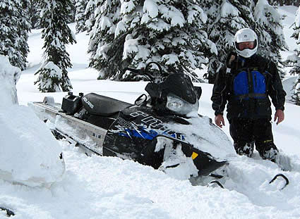 man standing beside a sled in snow