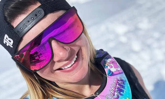 Close up of Kelsey smiling into the camera with sunglasses on