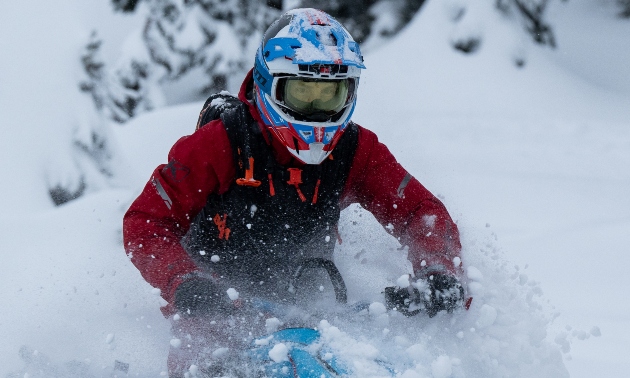 Marshall riding through snow, powder flying