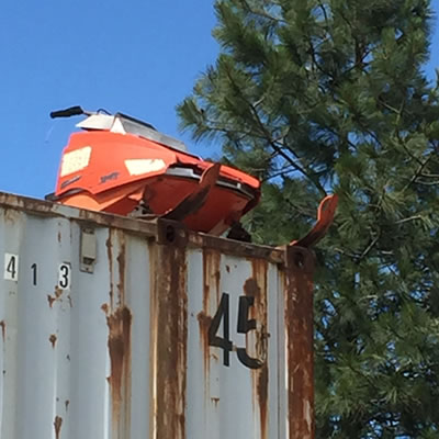 Picture of an old Moto-Ski snowmobile sitting on top of a storage container. 