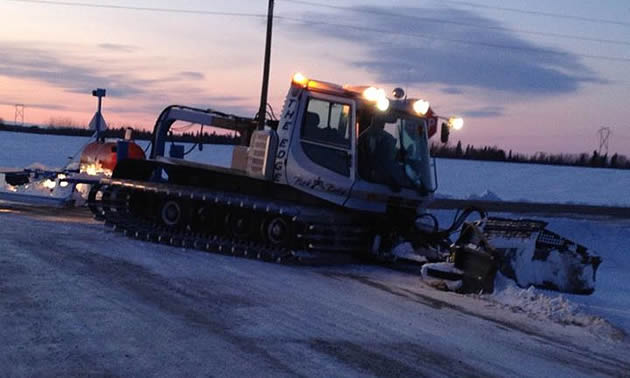 A snowmobile trail grooming machine with a drag behind it. 