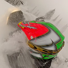 The back of a guys helmet while he is riding through the snow. 