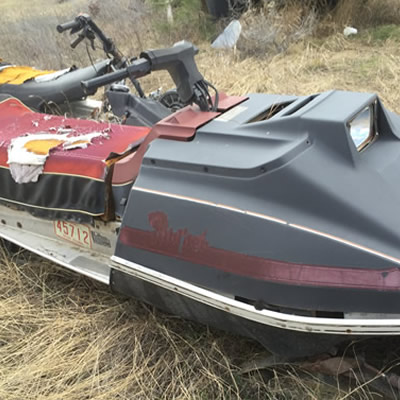 A rusting, forgotten Arctic Cat Pantera snowmobile.