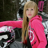 A young woman with long blonde hair sitting by a pink sled. 