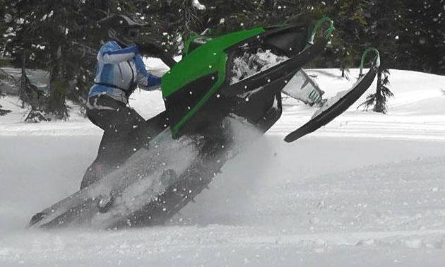 A woman catwalking on a green sled. 