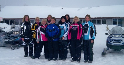 people gathered around a snowmobile