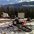 A mountain sled and trailers parked at a parking lot. 