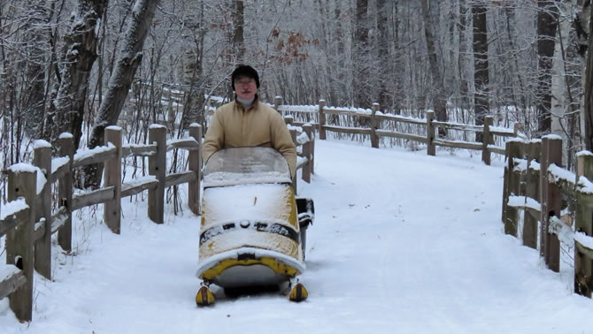 A man riding a Ski-Doo in winter