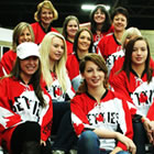 A group shot of women and girls wearing bright red jerseys. 