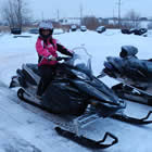 A woman on a stationary snowmobile