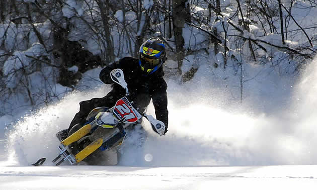 A rider rides his ski bike through the powder.