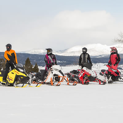 Group of snowmobilers on snowy mountainside