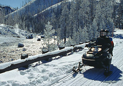Snowmobiler stops to enjoy a scenic view.