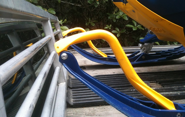 A snowmobile’s skis reach the back of a pickup truck’s window.