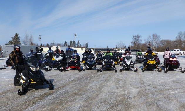 Bill Musey is standing next to his sled on the left in a brown suit.