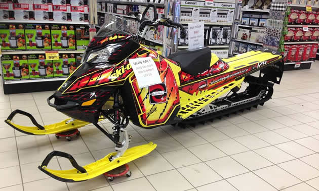 A new 2015 snowmobile sitting in a grocery store.