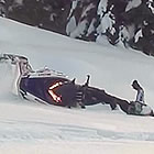 Photo of a women falling off her sled in the snow. 