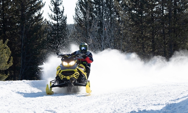 person riding a snowmobile on the trail