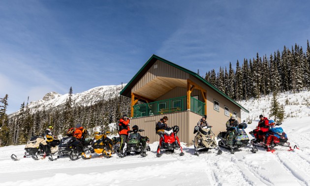 A group of sledders lined up in front of a shelter gearing up