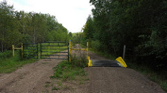 Part of the trail with a gate on the left and a ramp on the right for ATVs to cross. 