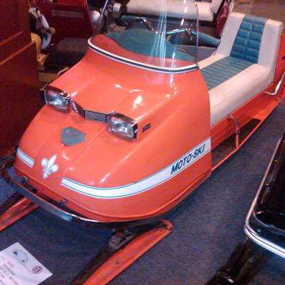 Picture of a restored Moto-Ski snowmobile. The colour is red. 