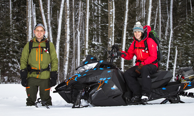 Shantelle and Andy Weir of Weir Boondocking standing by their sleds. 