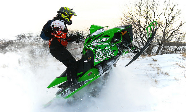 A rider on an Artic Cat hitting some drifts.